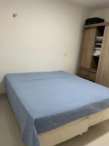 a bedroom with a blue bed and a wooden cabinet at In mare Bali Resort in Parnamirim +19 photos