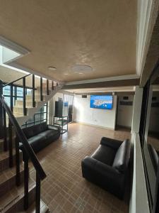 a living room with couches and a projection screen at Hotel MIRANDA in Tapachula