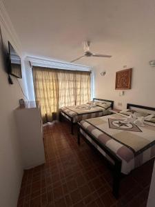 a room with two beds and a window at Hotel MIRANDA in Tapachula