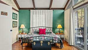a bedroom with green walls and a bed with a red pillow at The Four Seasonal by AvantStay Hot Tub Spacious Deck Fire Pit in Pocono Pines