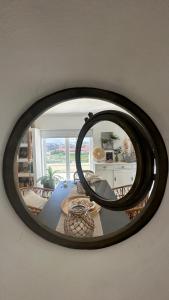a mirror hanging on a wall in a living room at Praia da Barra Sweet Home in Gafanha da Nazaré