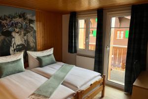 a bedroom with a bed with a picture of a cow on the wall at Chalet Alpenheim 2 OG in Bettmeralp