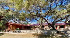 a house with a large tree in front of it at Casa Floerke in Concan
