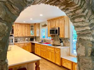 a kitchen with wooden cabinets and a stone wall at Casa Floerke in Concan