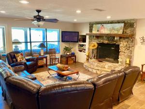 a living room with leather furniture and a stone fireplace at Casa Floerke in Concan