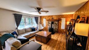 The Wooden Nest by AvantStay Deck Big Yard w Hammocks Fire Pit في Long Pond: غرفة معيشة بها أريكة وطاولة