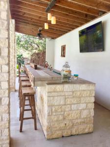 an outdoor kitchen with a stone counter and stools at Agave Point in Concan