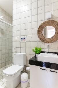 a bathroom with a toilet and a sink and a mirror at Casa a 100 metros do mar- no Centro de Porto de Galinhas in Porto De Galinhas