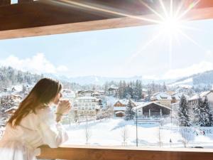 نوفوتيل ميجيف مونت بلانك في ميجيف: امرأة تطل من النافذة على جبل ثلجي