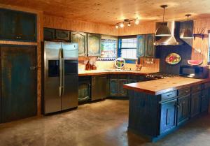 a kitchen with wooden cabinets and a stainless steel refrigerator at Agua Bonita in Concan