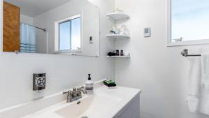 a white bathroom with a sink and a mirror at Saratoga by the Sea by AvantStay Panoramic View Near Langley in Langley +22 photos