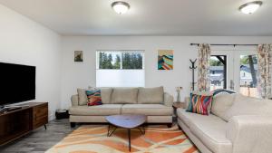 a living room with two couches and a flat screen tv at Twin Oaks Retreat by AvantStay Mins to Freeland in Langley