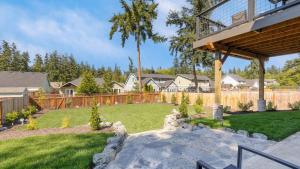 a backyard with a wooden fence and a yard at Twin Oaks Retreat by AvantStay Mins to Freeland in Langley