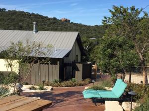 a patio with a green chair and a building at Kickin Back in Concan