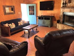 a living room with couches and a table and a television at Kickin Back in Concan