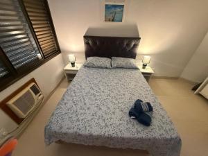 a bedroom with a bed with a blue hat on it at Residencial Ponta das Canas in Florianópolis +29 photos