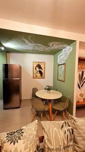 uma sala de jantar com uma mesa e um frigorífico em Solar Águas Pipa Stays em Pipa mais 7 fotografias