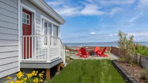 a patio with red chairs and a table on the side of a house at Harrington Hideaway by AvantStay Beach Access in Coupeville