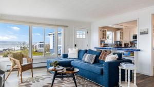 a living room with a blue couch and a large window at Harrington Hideaway by AvantStay Beach Access in Coupeville