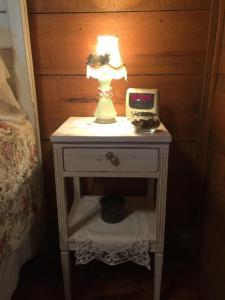 a nightstand with a lamp and a clock on it at La Casita in Concan