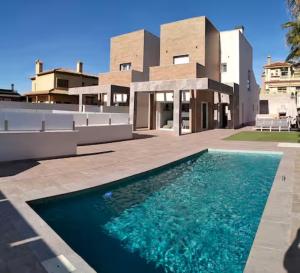 a house with a swimming pool in front of a house at Villa Domicil de Luxe in Torrevieja