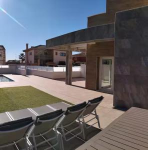 a patio with chairs and a table on a roof at Villa Domicil de Luxe in Torrevieja