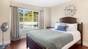 a bedroom with a large bed and a window at Grapevine by AvantStay Secluded 5BR Villa 4 Acres of Vineyards Avo Groves in Temecula +92 photos