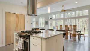 a kitchen with a stove and a dining room at Secluded Modern Enclosed Patio Forest Views Woodland Zen by AvantStay in Stockbridge