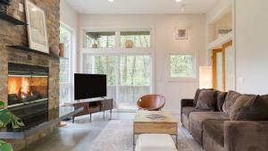 a living room with a couch and a fireplace at Secluded Modern Enclosed Patio Forest Views Woodland Zen by AvantStay in Stockbridge