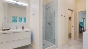 a white bathroom with a shower and a sink at Secluded Modern Enclosed Patio Forest Views Woodland Zen by AvantStay in Stockbridge +27 photos