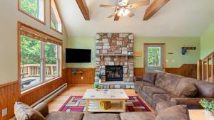 Una sala de estar con un sofá y una chimenea. en Coyote Cabin by AvantStay Hot Tub Walk to Lake, en Lake Harmony