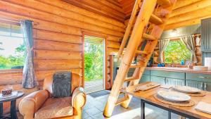 Penn Cove Overlook by AvantStay Cabin w Views في أوك هاربور: مطبخ كوخ خشبي مع سلم وطاولة