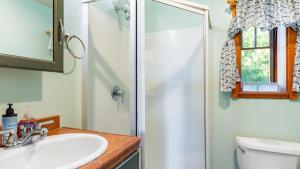 Penn Cove Overlook by AvantStay Cabin w Views في أوك هاربور: حمام مع دش ومغسلة ومرحاض