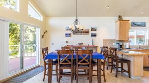 Harborview Getaway by AvantStay Walk to Beach في لانغلي: غرفة طعام مع طاولة وكراسي زرقاء