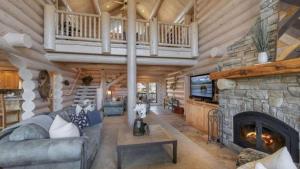 Cabaña de madera con sala de estar con chimenea de piedra. en Hot Tub Game Room Large Deck w Incredible View Penticton Lodge by AvantStay, en Big Bear Lake