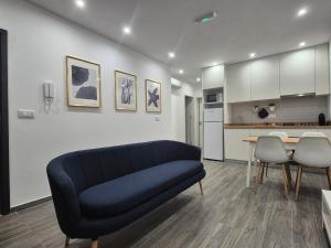 a living room with a blue couch and a kitchen at Casa Morada in Mindelo