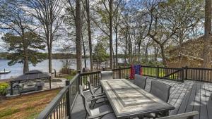 a deck with a table and chairs and a grill at Laid Back Lake Life by AvantStay Waterfront View in Mooresville