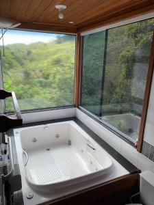 Sítio Reichart Atlantic Forest Retreat في ماريشال فلوريانو: حوض استحمام كبير في غرفة مع نافذة