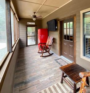 eine Veranda mit einer Bank und einem roten Kühlschrank in der Unterkunft Heartrock in Concan