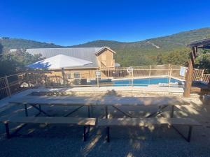 a picnic table in front of a house with a pool at HILLSIDE in Concan