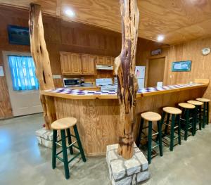 a kitchen with a bar with stools and a tree at HILLSIDE in Concan