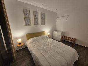 a bedroom with a bed and two lights on the wall at Casa Morada in Mindelo