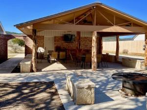 a covered patio with a television and tables and chairs at North Star in Concan