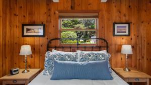 a bedroom with a bed with wooden walls and a window at The Pilot House by AvantStay Stunning Home Right On Arch Cape Beach in Arch Cape