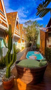 a patio with a cactus and a swimming pool at VILLAM AREIA FOFA in Bombinhas