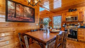 ein Esszimmer mit einem Holztisch und Stühlen in der Unterkunft Misty Mountain by AvantStay Hot Tub Mountain Views Theater Pool Table in Gatlinburg