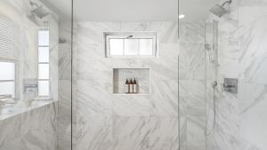 a shower with a glass door in a bathroom at Canalfront Charmer by AvantStay Waterfront w Shared Dock Hot Tub in Newport Beach +39 photos