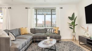 Desert Eden by AvantStay 6BR w Ensuite Backyard Oasis w Pool Hot Tub في كوتشيلا: غرفة معيشة بها أريكة وطاولة