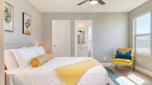 Desert Eden by AvantStay 6BR w Ensuite Backyard Oasis w Pool Hot Tub في كوتشيلا: غرفة نوم بها سرير وكرسي أصفر +37 صورة