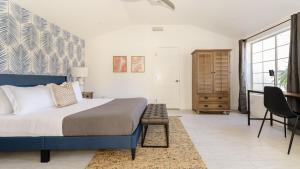 Casa Piña by AvantStay Vibrant Palm Springs Oasis w Colorful Stylish Design في لا كينتا: غرفة نوم بها سرير وطاولة وكرسي +22 صورة